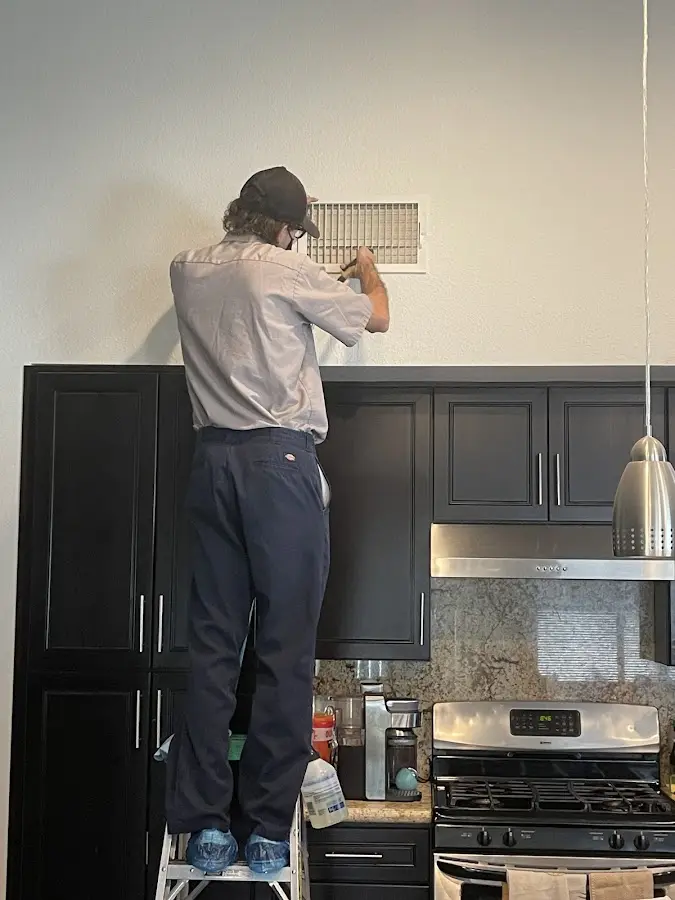 Technician inspecting an air vent during HVAC service in Sheboygan Falls